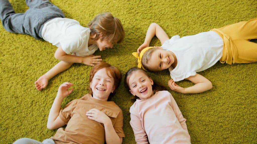 Happy Kids Lying on Textured Carpet